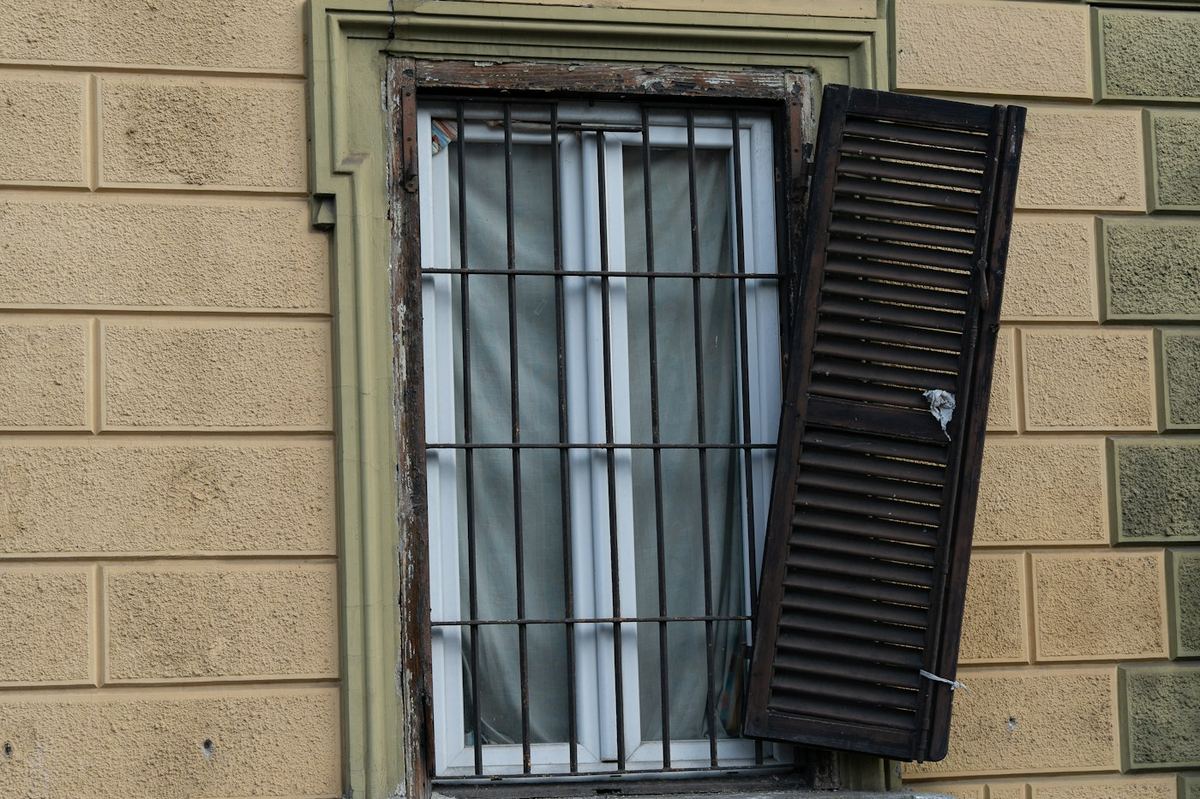 Ventana con reja metálica y contraventana abierta