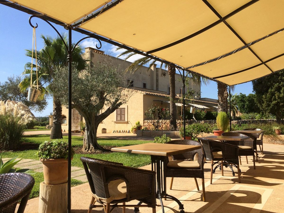 Terraza con toldo sobre las mesas